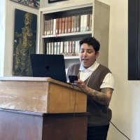 Laine Barriga standing at podium presenting paper